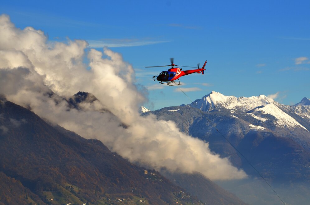 helicopter-flying-clouds-snow-capped-mountains_181624-19186 (1)